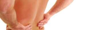 A person's hands gripping their lower back, indicating back pain.